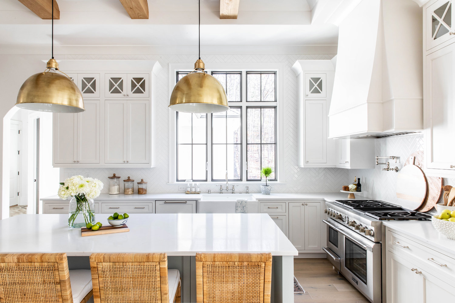 Bright Plattner Builders kitchen with wood beams and brass pendants